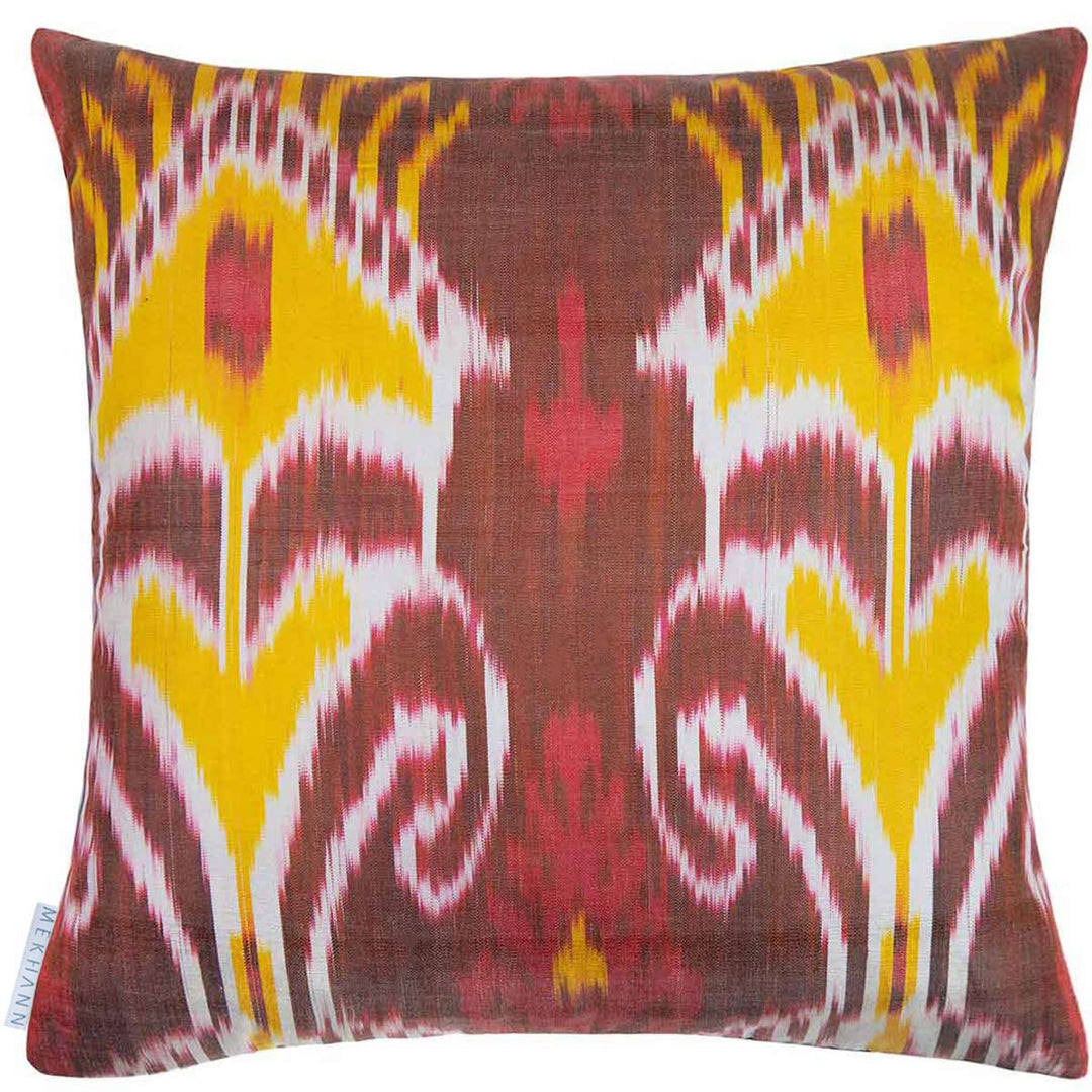 Back view of Mekhann's black grapes and pomegranates embroidered cushion, revealing the bright yellow, red, brown and white ikat back lining.
