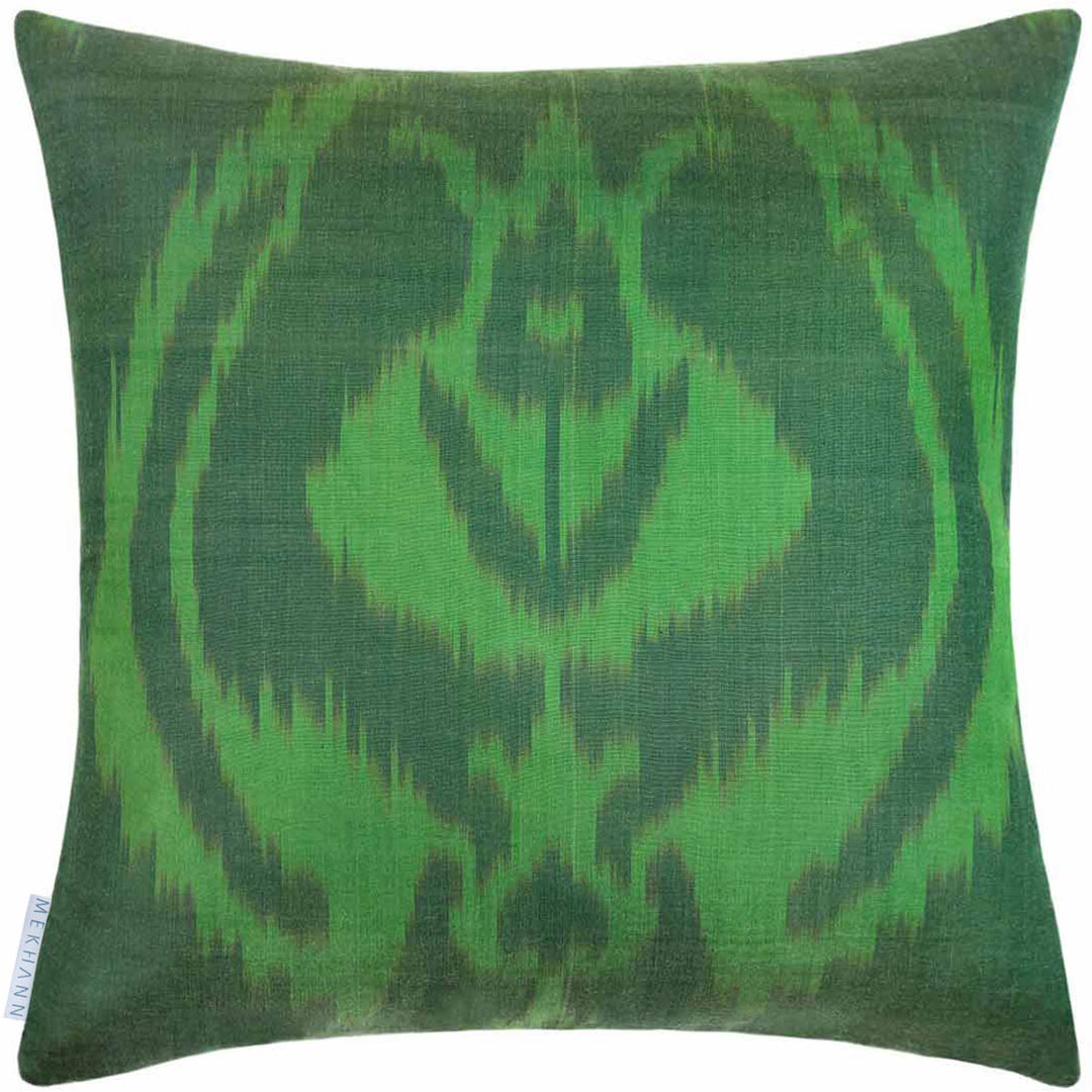 Back view of Mekhann's black and green Cintamani embroidered cushion, where the emerald green ikat fabric used for the back face of the cushion can be seen in full.