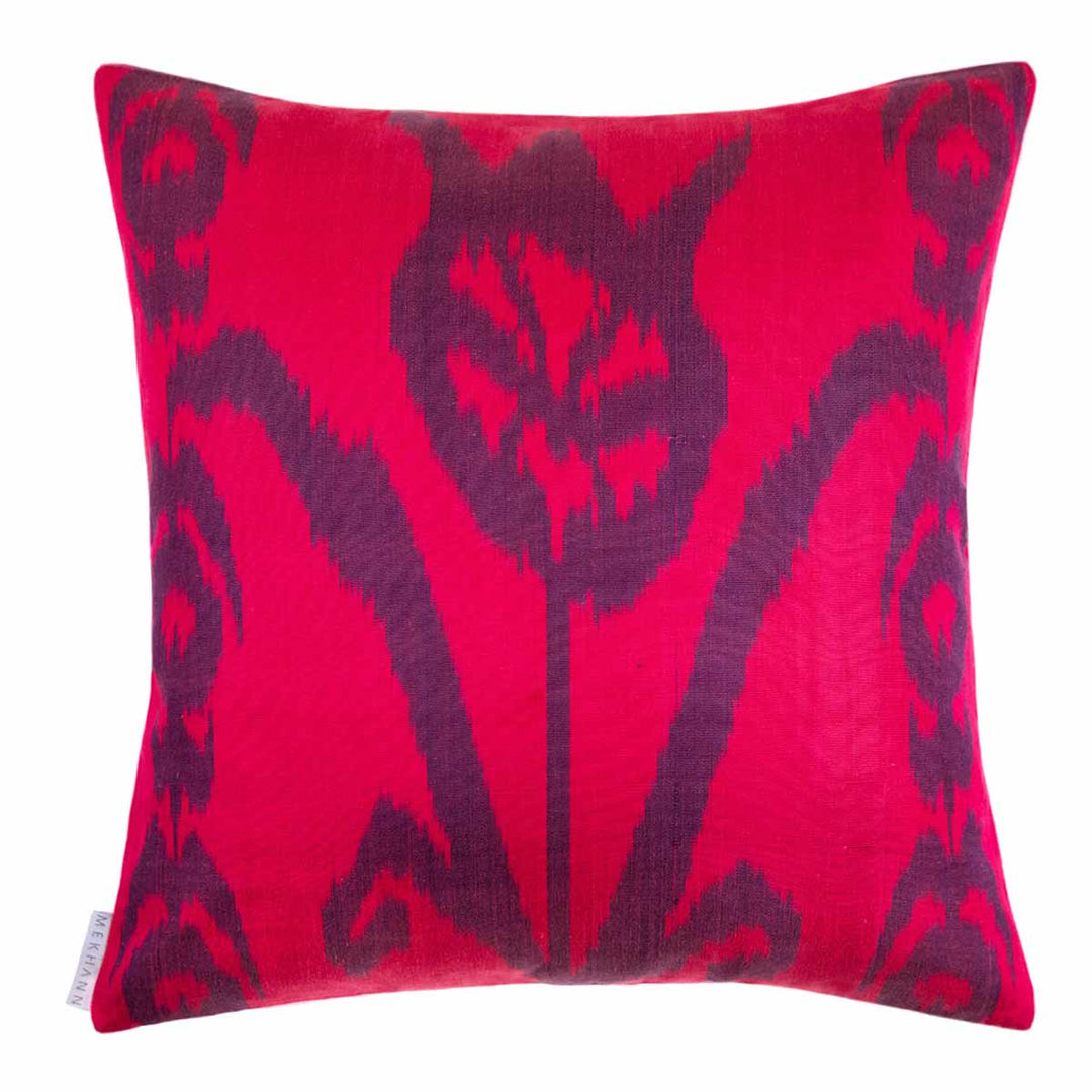 Back view of Mekhann's pink sunflower embroidered cushion, revealing a bight pink and dark purple toned ikat back lining.