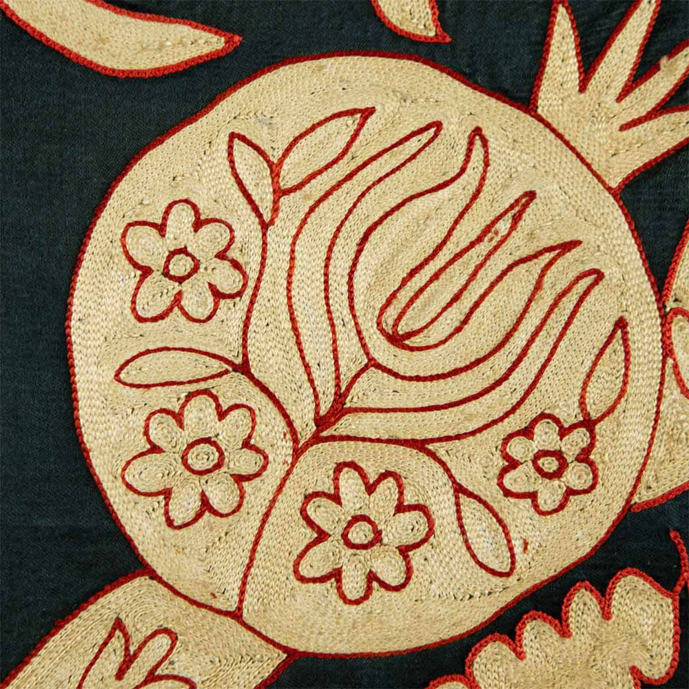 Detailed view of Mekhann's black pomegranate vines throw. The attention to detail in unmatched with the cream, hand embroidered, pomegranate Motif adorned with a delicate red thread to add dimension and define it against the black silk backdrop.