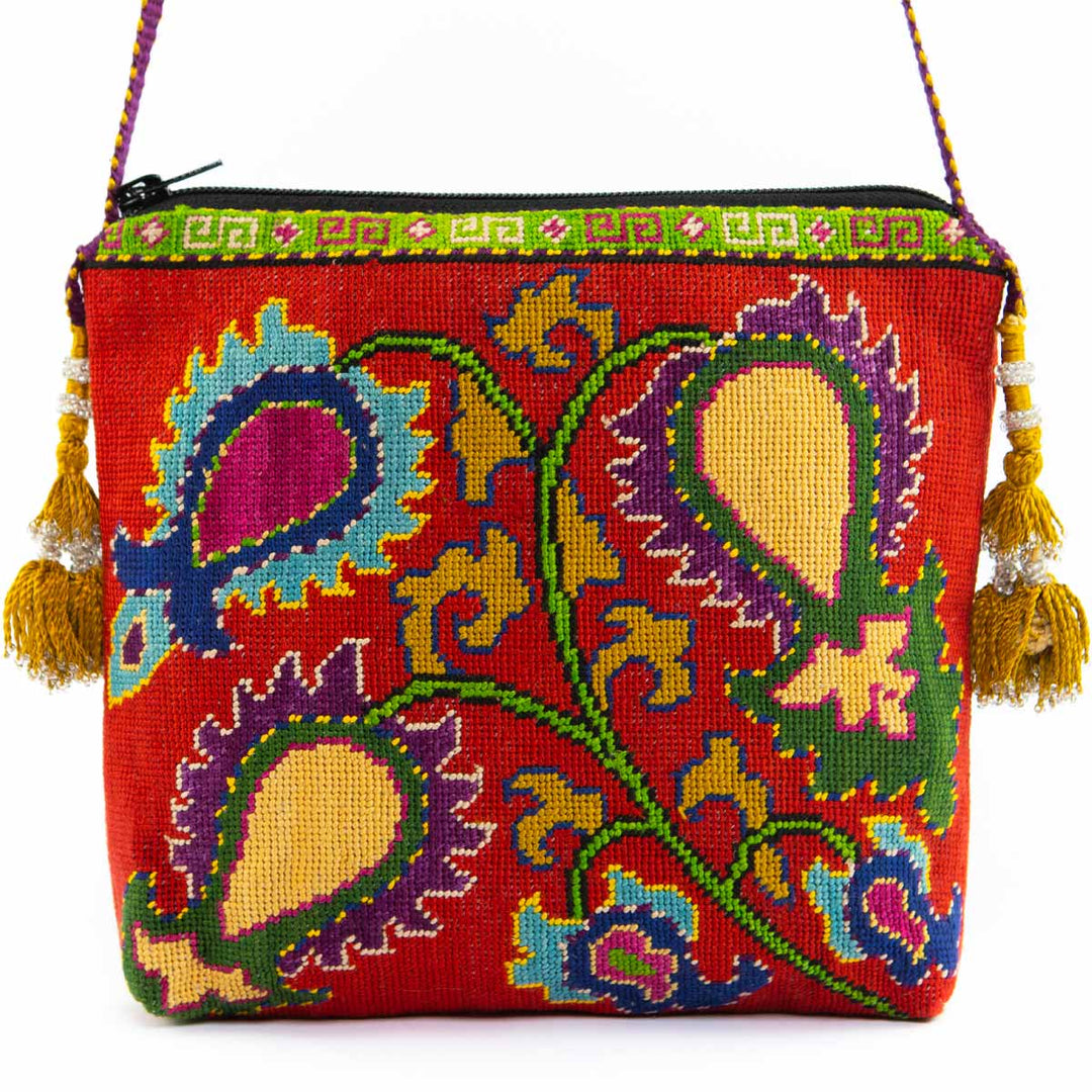 Front view of Mekhann's red botanical embroidered cross-body bag, with detailed hand-embroidery and golden tassel accents. 