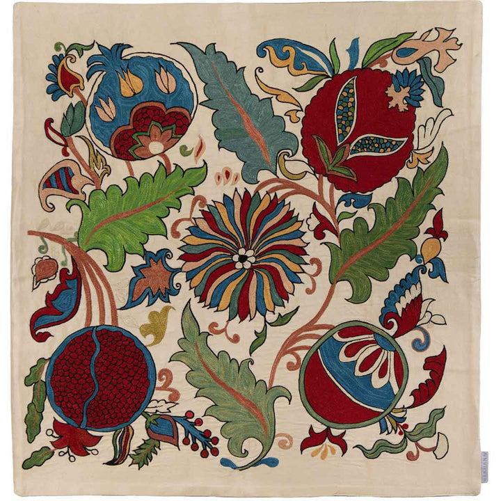 Front view of Mekhann's botanical cream petite throw, an elegant cream-coloured throw with vibrant botanical embroidered patterns that have been hand embroidered with the main colours being red, blue and green.