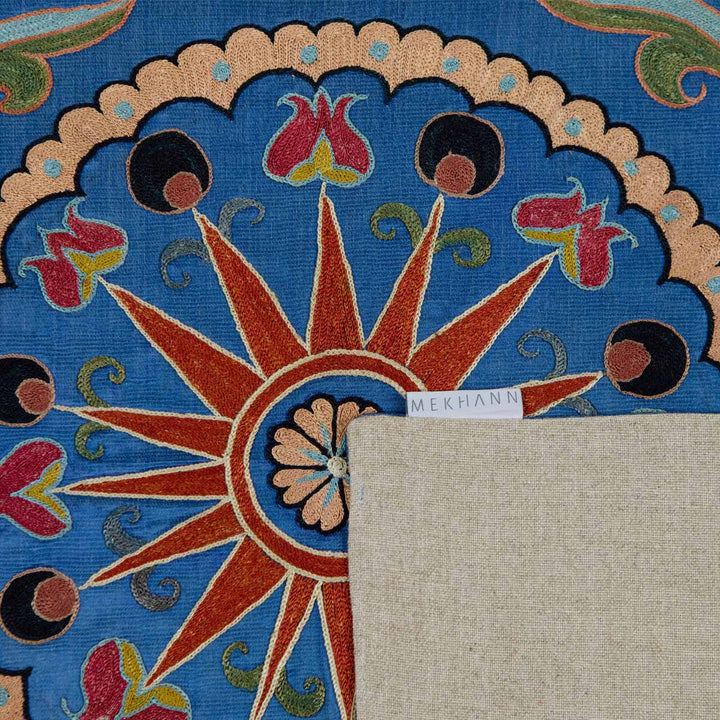 Folded view of Mekhann's navy botanical petite throw, showing the back lining of the throw with the Mekhann label attached to the side.