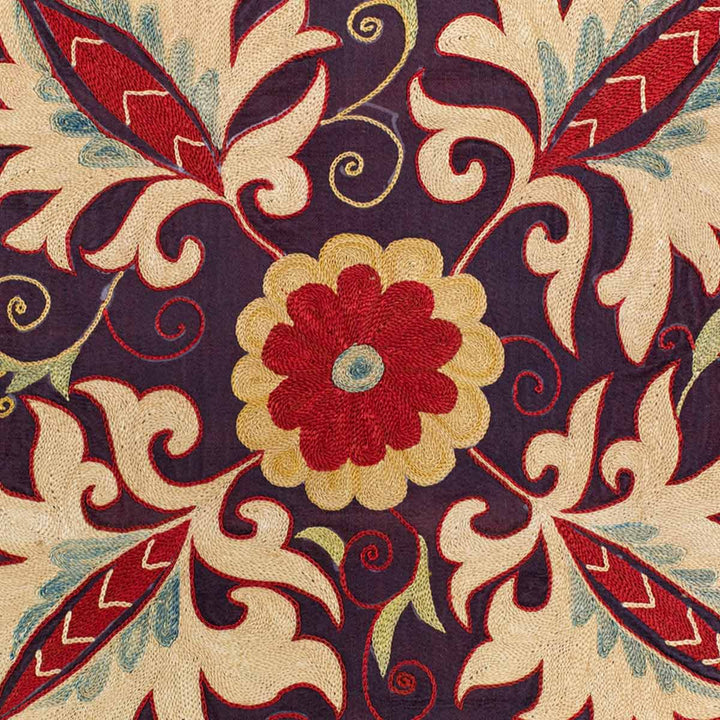 Close up view of Mekhann's purple botanical runner, showing the elaborate botanical embroidery against the purple silk background.