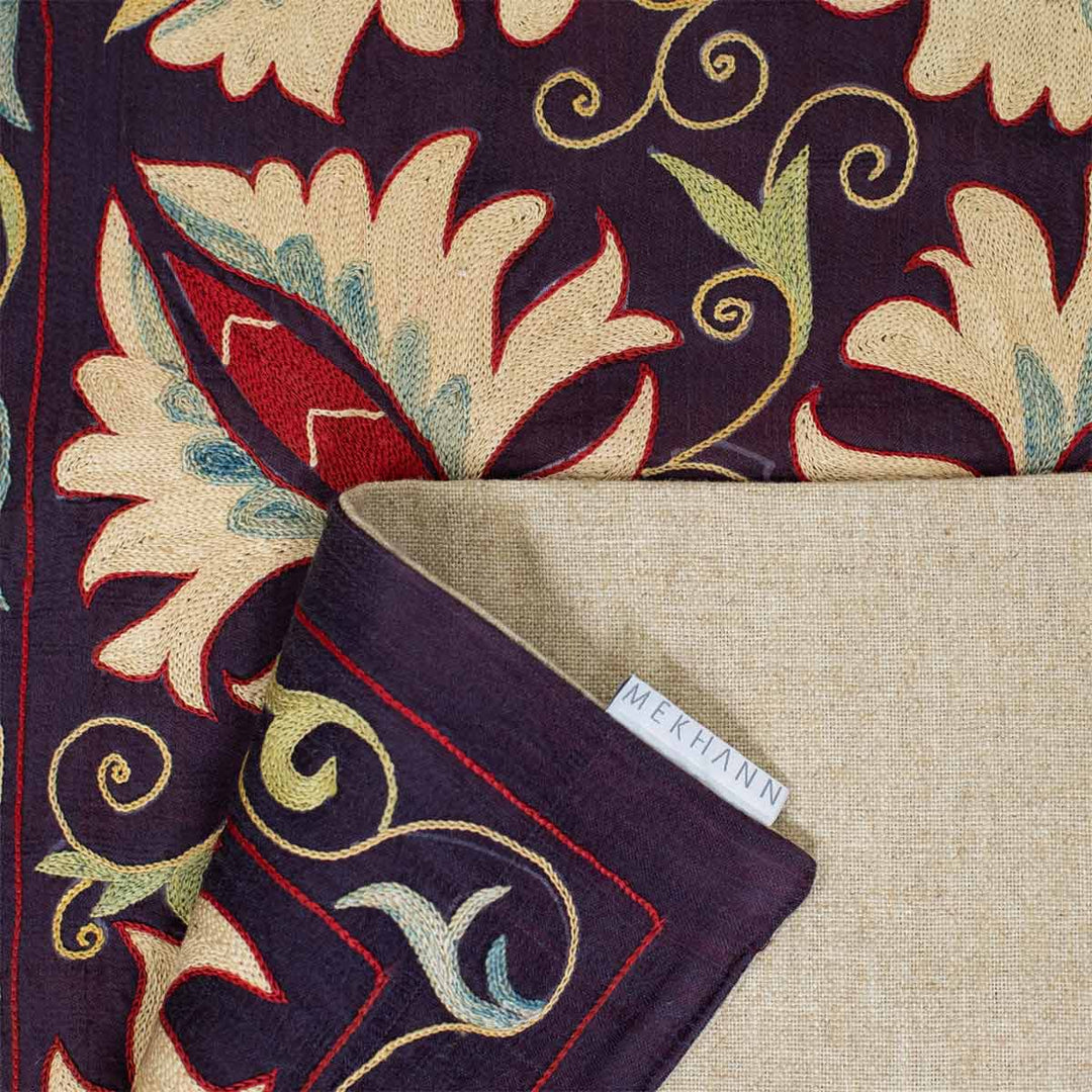 Folded view of Mekhann's purple botanical runner, showcasing the back lining of the botanical runner.
