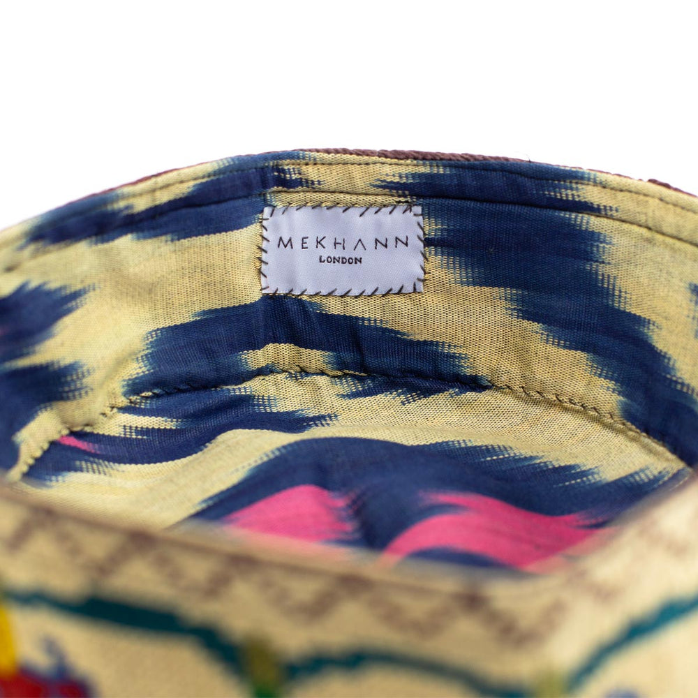 Inside view of Mekhann's botanical cream skull cap, showing the inside view of the ikat lining that goes beautifully with the embroidered exterior.