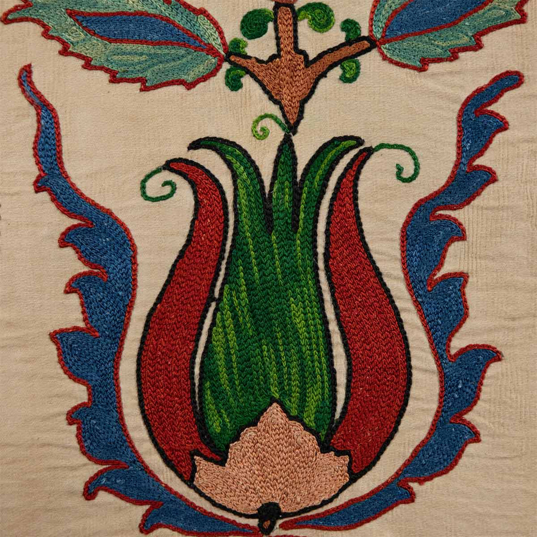 Close up view of Mekhann's carnations petite throw, highlighting the rich texture and intricate embroidery of Mekhann's cream throw with carnation motifs.