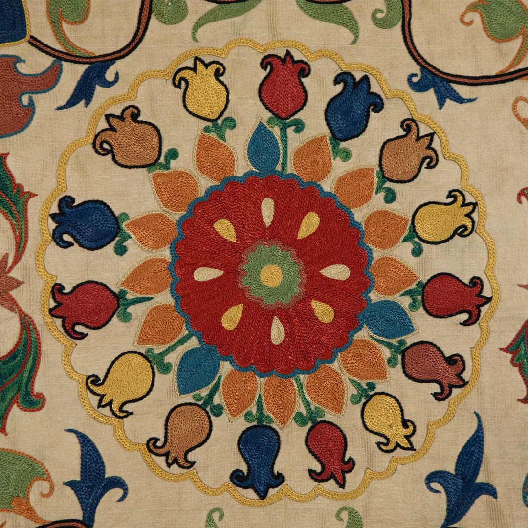 Close up view of Mekhann's carnations petite throw, highlighting the rich texture and intricate embroidery of Mekhann's cream throw with carnation motifs.