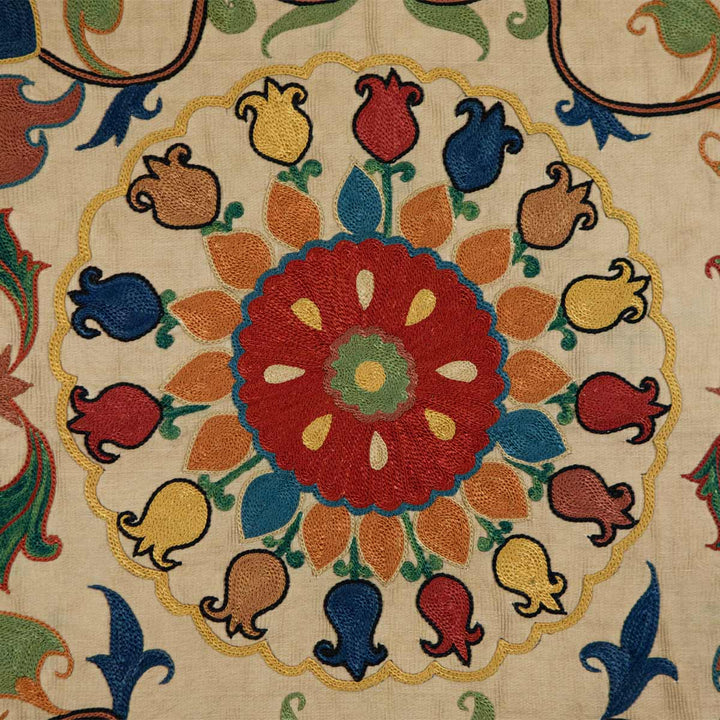 Close up view of Mekhann's carnations petite throw, highlighting the rich texture and intricate embroidery of Mekhann's cream throw with carnation motifs.