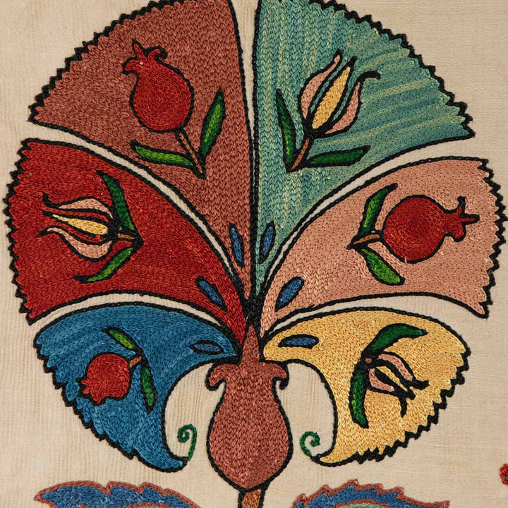 Detailed view of Mekhann's carnations petite throw, bringing you close to the texture and intricate embroidery of the cream throw with carnation motifs.