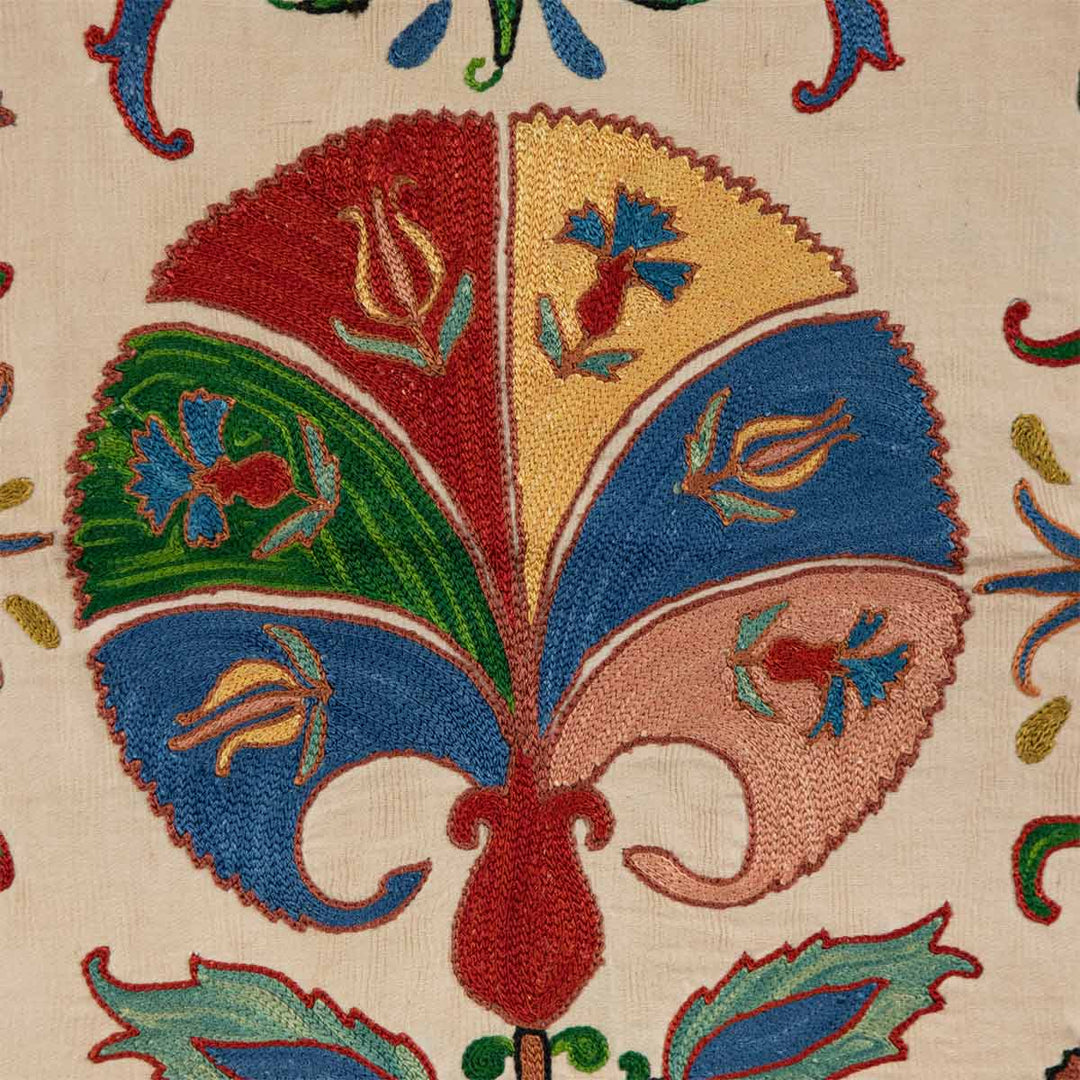 Detailed view of Mekhann's carnations petite throw, a cream throw featuring hand-embroidered carnations with colourful accents.