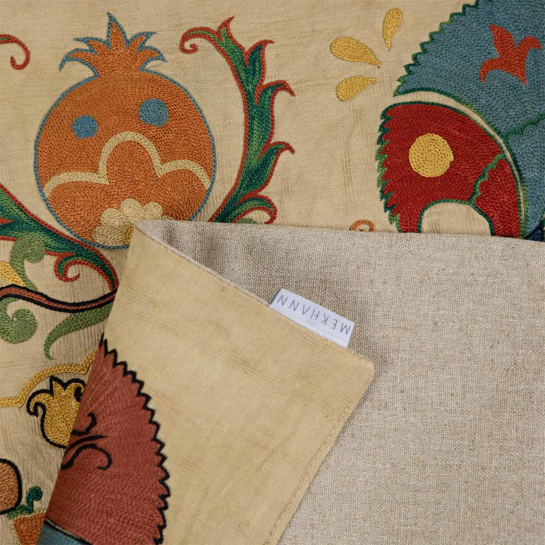 Folded view of Mekhann's carnations petite throw, showing the back lining of the throw alongside the Mekhann label.