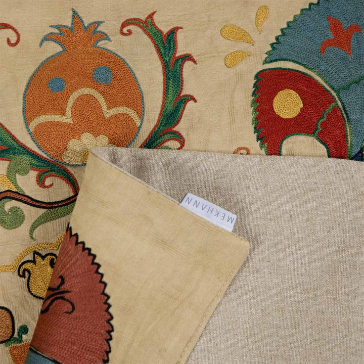 Folded view of Mekhann's carnations petite throw, showing the back lining of the throw alongside the Mekhann label.