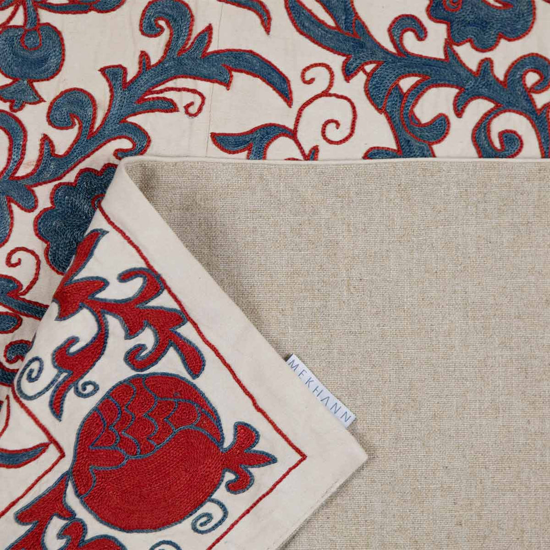 Folded view of Mekhann's cream carnations tree throw, revealing the back lining of the carnations tree throwing how the silk looks next to it for colour referencing.