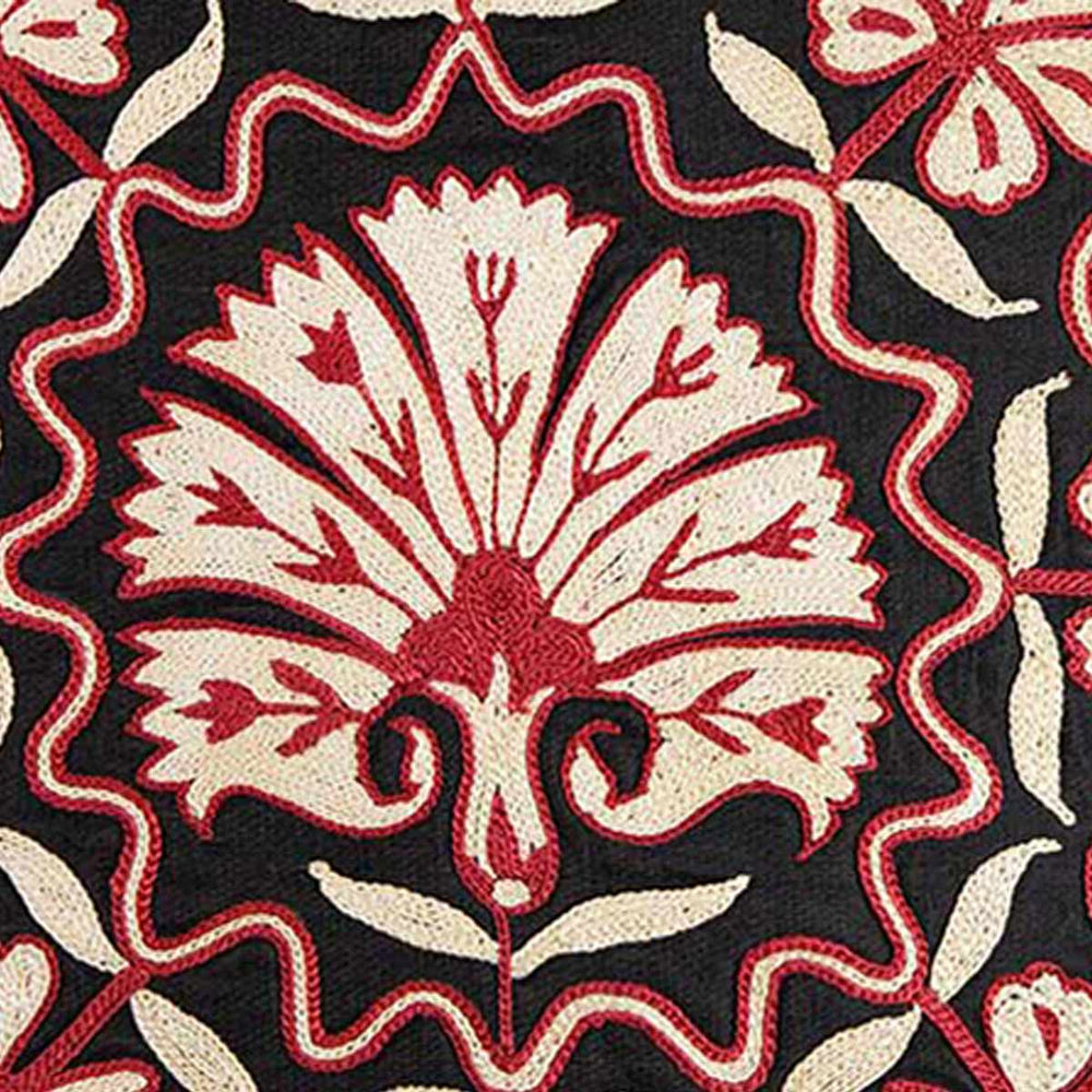 Close up view of Mekhann's red and black carnations embroidered cushion, showing the texture of the carnations embroidered that has been created using cream and red silk thread.