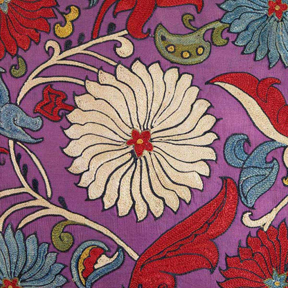 Close up view of Mekhann's pink sunflower embroidered cushion, here we can see a floral motif that has been embroidered in the centre of the cushion agonist the purple silk front lining.