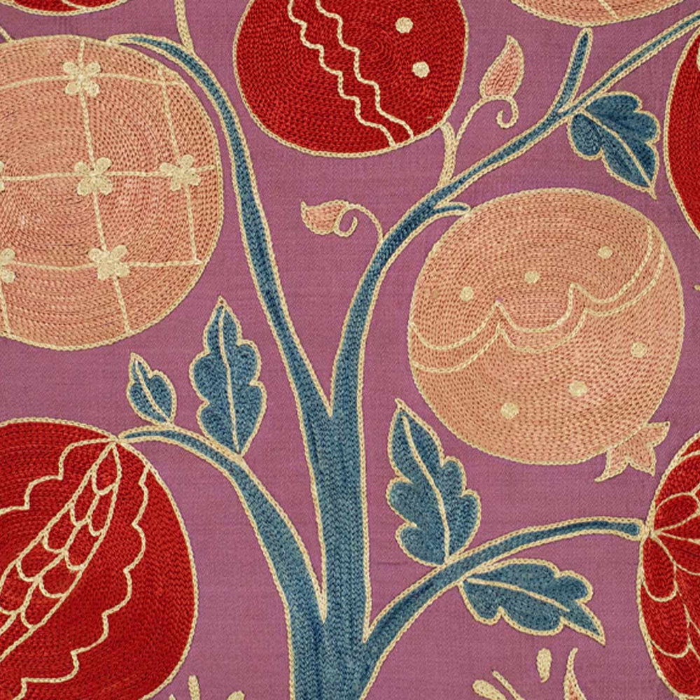 Close up view of Mekhann's multicoloured pomegranates tree embroidered cushion, where we can see the teal tree branches with the embroidered pomegranate motifs growing from them.
