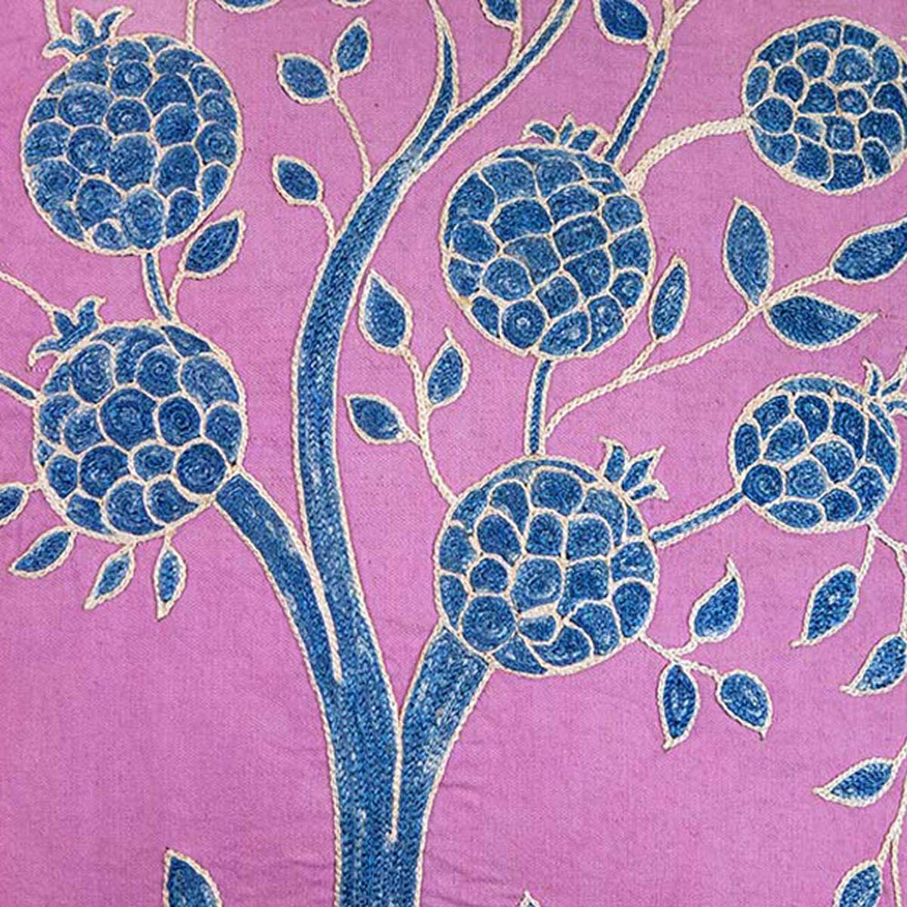 Close up view of Mekhann's multicoloured pomegranate embroidered cushion, the pomegranates have been hand embroidered in navy blue and outlined in a light cream all on a silk base of purple.