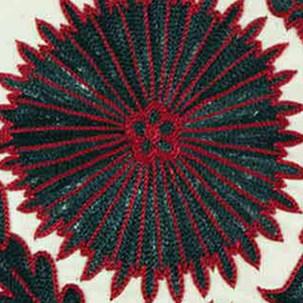 Close-up view of Mekhann's multicoloured Sunflower embroidered cushion, highlighting the detailed stitching of the sunflower design on Mekhann's cushion using dark green and red silk yarns to create the embroidered sunflower design.