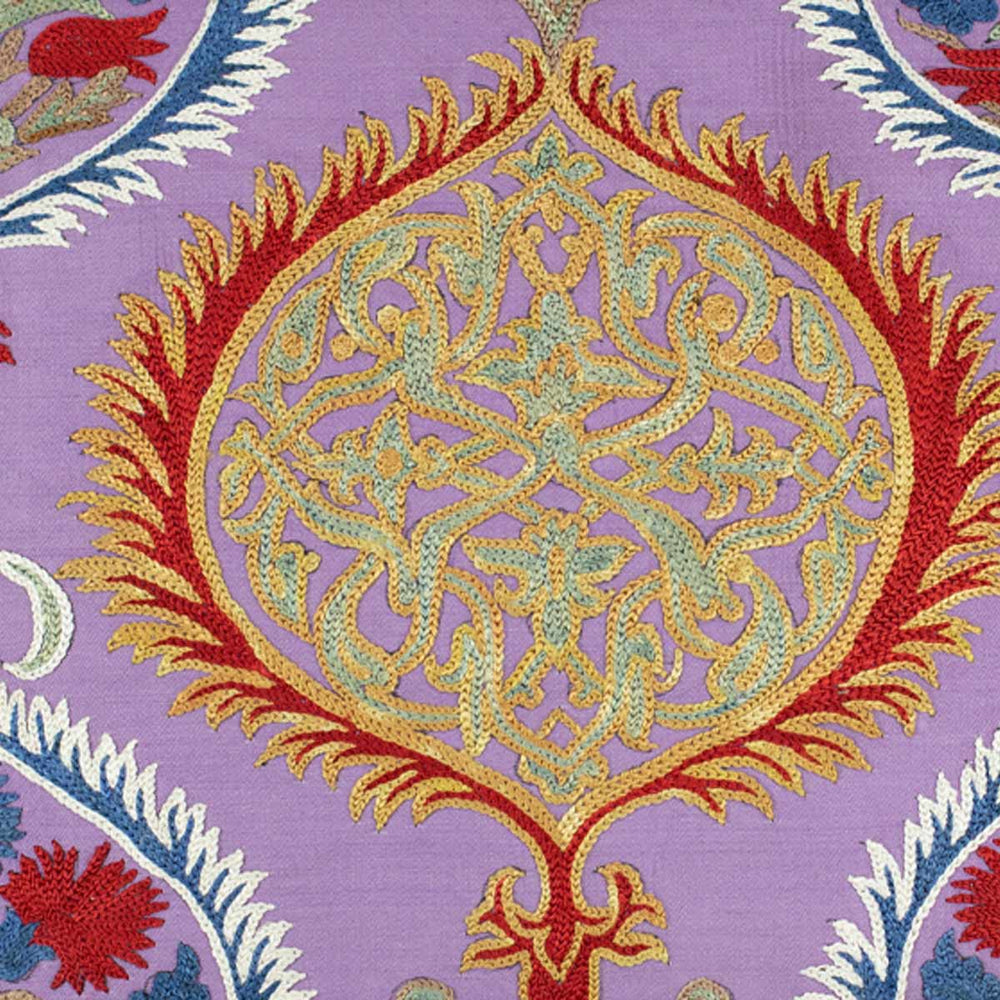 Close up view of Mekhann's multicoloured Topkapi embroidered cushion, showing one of the Topkapi motifs up close that has been executed using red, green and beige silk yarns.