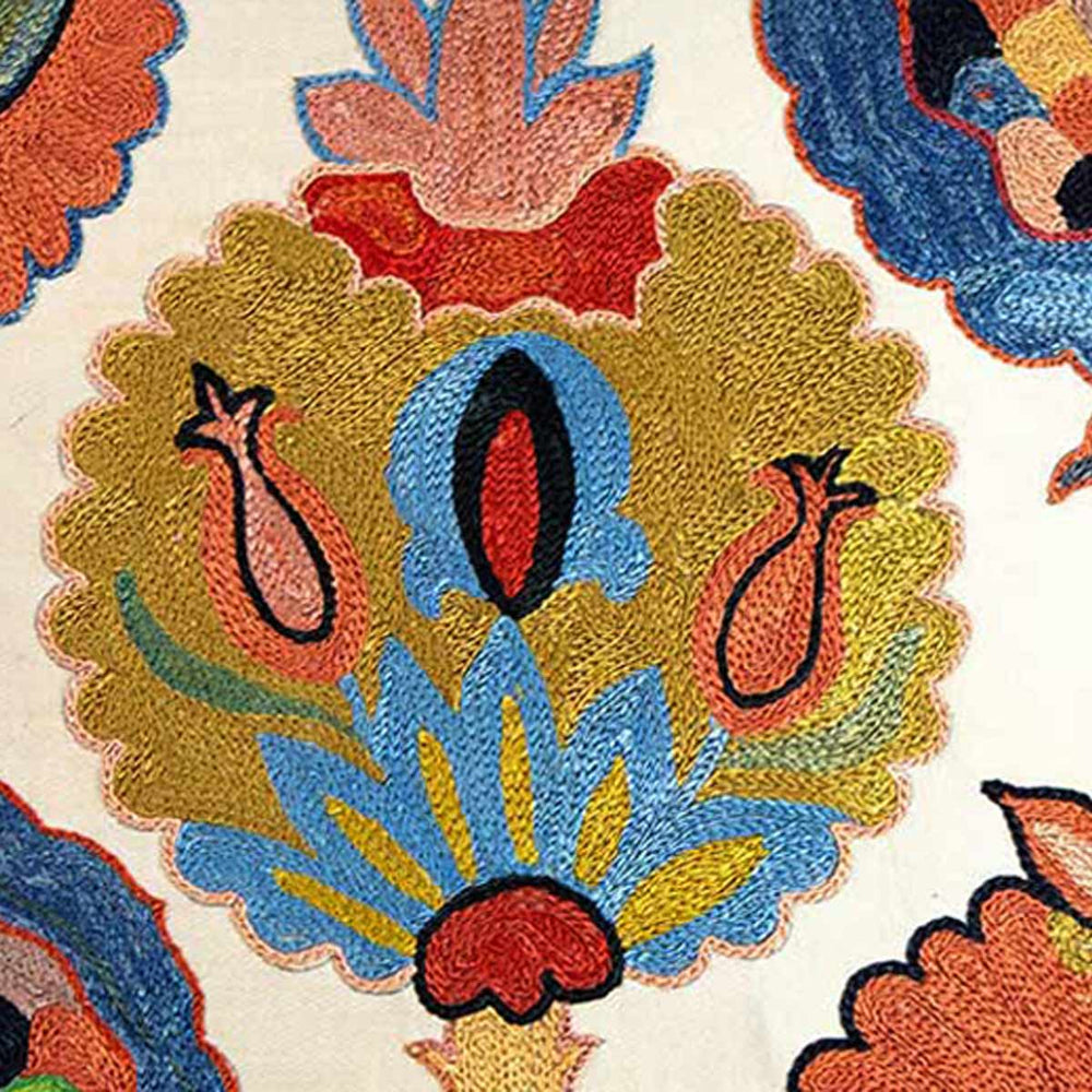 Close up view of Mekhann's Topkapi embroidered cushion, showcasing one of the iznik design motifs created using blue, orange, red and yellow silk yarns.