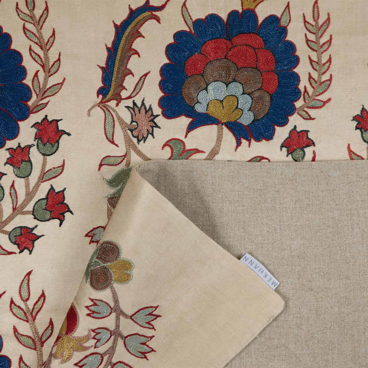 Folded view of Mekhann's cream botanical throw, folded view, showing texture and fabric quality of the back lining of the throw.