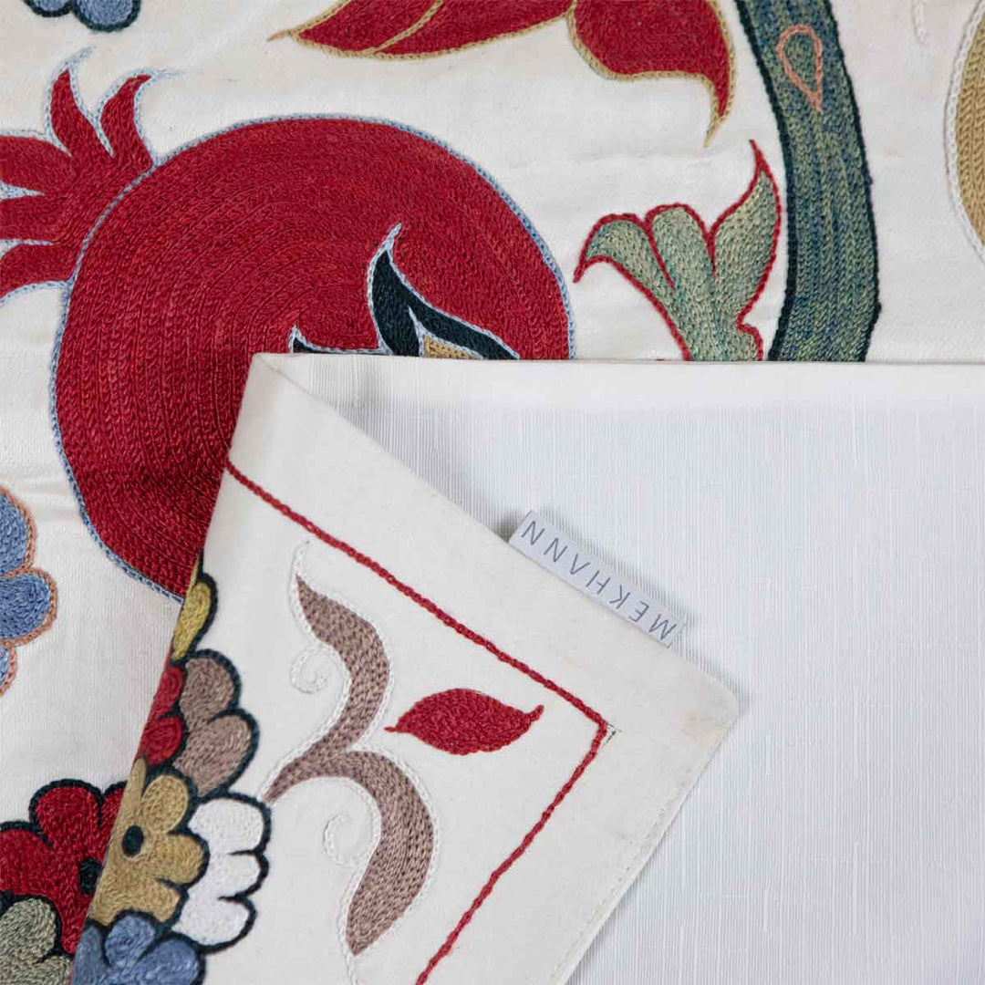 Folded view of Mekhann's cream ottoman vines runner, revealing the white lining with the Mekhann branded label.