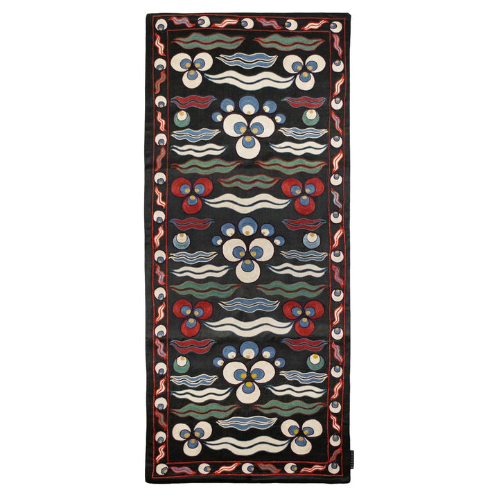 Front view of Mekhann's black cintamani runner, showing a display hand embroidered silk cintamani patterns on a black silk base with a multitude of patterns in colours blue, red, and white.