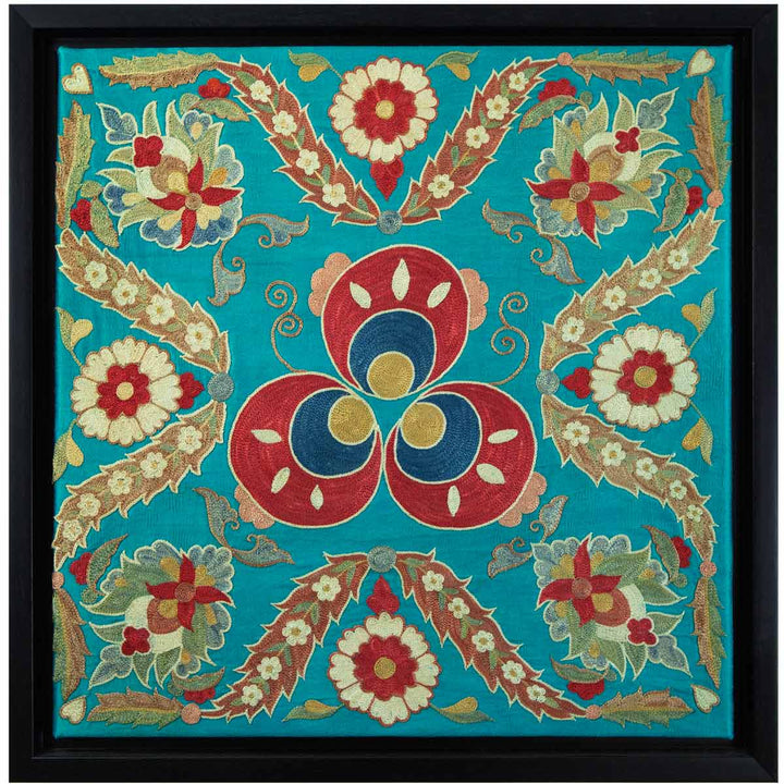 Front view of Mekhann's floral turquoise silk embroidered artwork, with a collection of embroidered flowers and leaves in red, cream, and brown on a base of turquoise silk, all with a black frame.