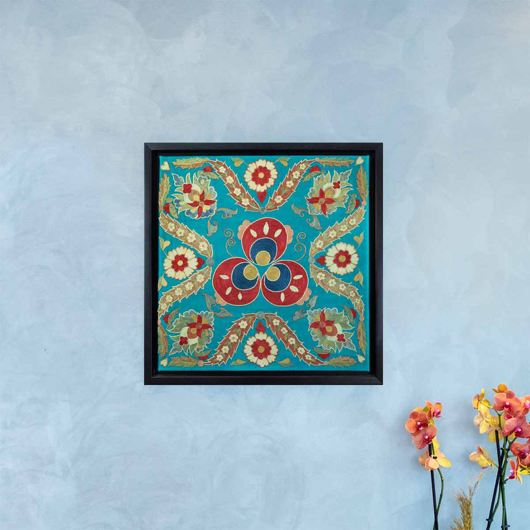 In use view of Mekhann's floral turquoise silk embroidered artwork, where we can see the turquoise framed artwork on a large wall to better understand the size of the artwork.