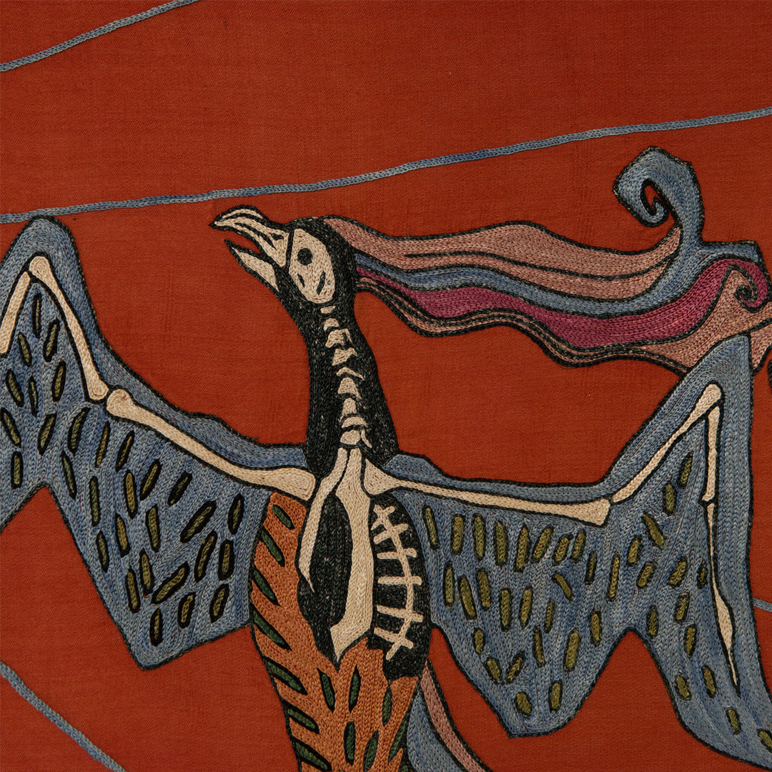 Detail view of Mekhann's maroon silk hand embroidered phoenix artwork, showing one of the phenix's bones revealed over the body.
