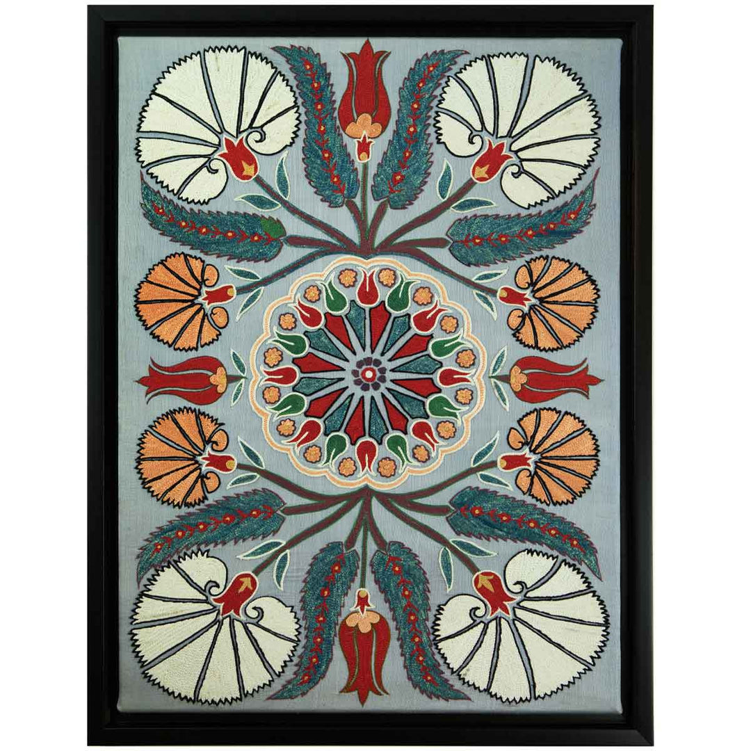 Front view of Mekhann's grey silk carnations artwork, with a display of cream, and orange carnations, including some small red tulips, all hand embroidered on a grey silk background. All of this finished off with a black frame.