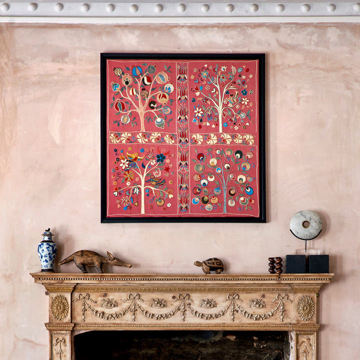 In use view of Mekhann's pink silk hand embroidered artwork, shown above a fireplace to give sizing context for the artwork.