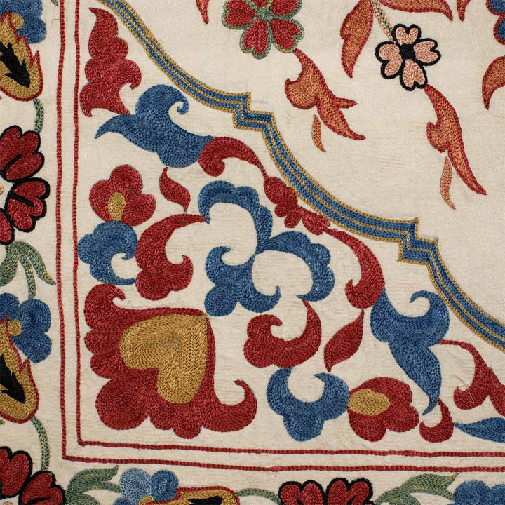 Close up view of Mekhann's cream iznik throw, where we can see a corner of the throw, and all of the dedication and precision that has gone into creating this hand embroidered throw.