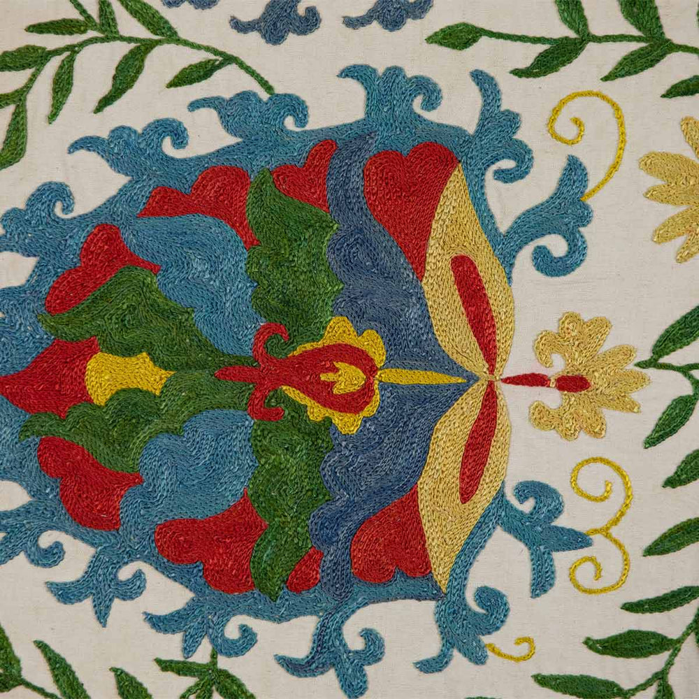 Close up view of Mekhann's cream iznik petite throw, highlighting the delicate embroidery and rich colour details of the design.