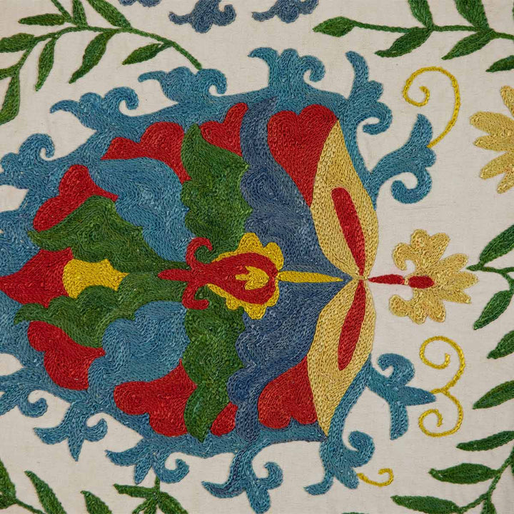 Close up view of Mekhann's cream iznik petite throw, highlighting the delicate embroidery and rich colour details of the design.