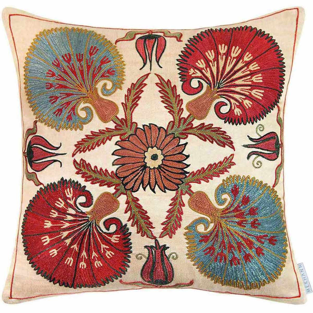 Front view of Mekhann's cream carnations embroidered cushion, where we can see the display of four main carnations in the colours blue and red, surrounded by smaller flower motifs, all hand embroidered onto a cream coloured silk canvas.