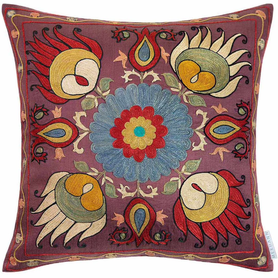 Front view of Mekhann's multicoloured lotus embroidered cushion, where we can see a collection of four main lotus designs that have been hand embroidered in bright bred, green and yellow with a black outline. All have been embroidered onto a dark purple silk base.