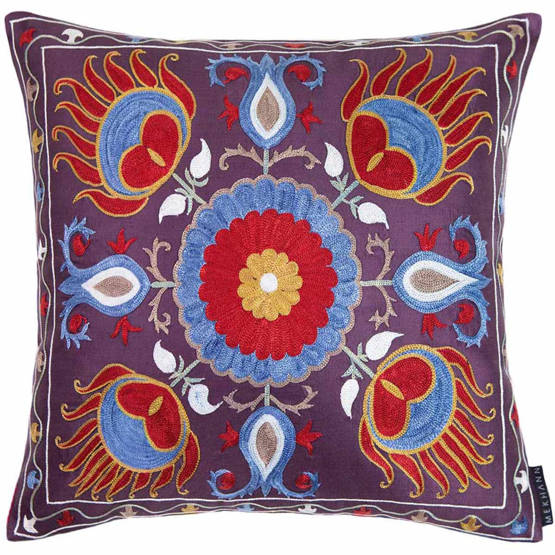 Front view of Mekhann's multicoloured lotus embroidered cushion, showing a colourful composition of red, blue and cream embroidery all on a base of dark purple.