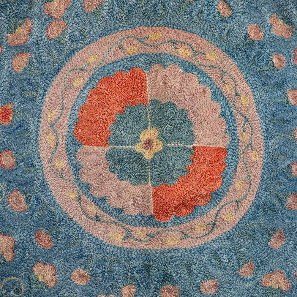 Detailed view of Mekhann's fully embroidered lividus II kaftan in navy, displaying a medallion motif in soft lilac and soft red to create a muted and delicate design.