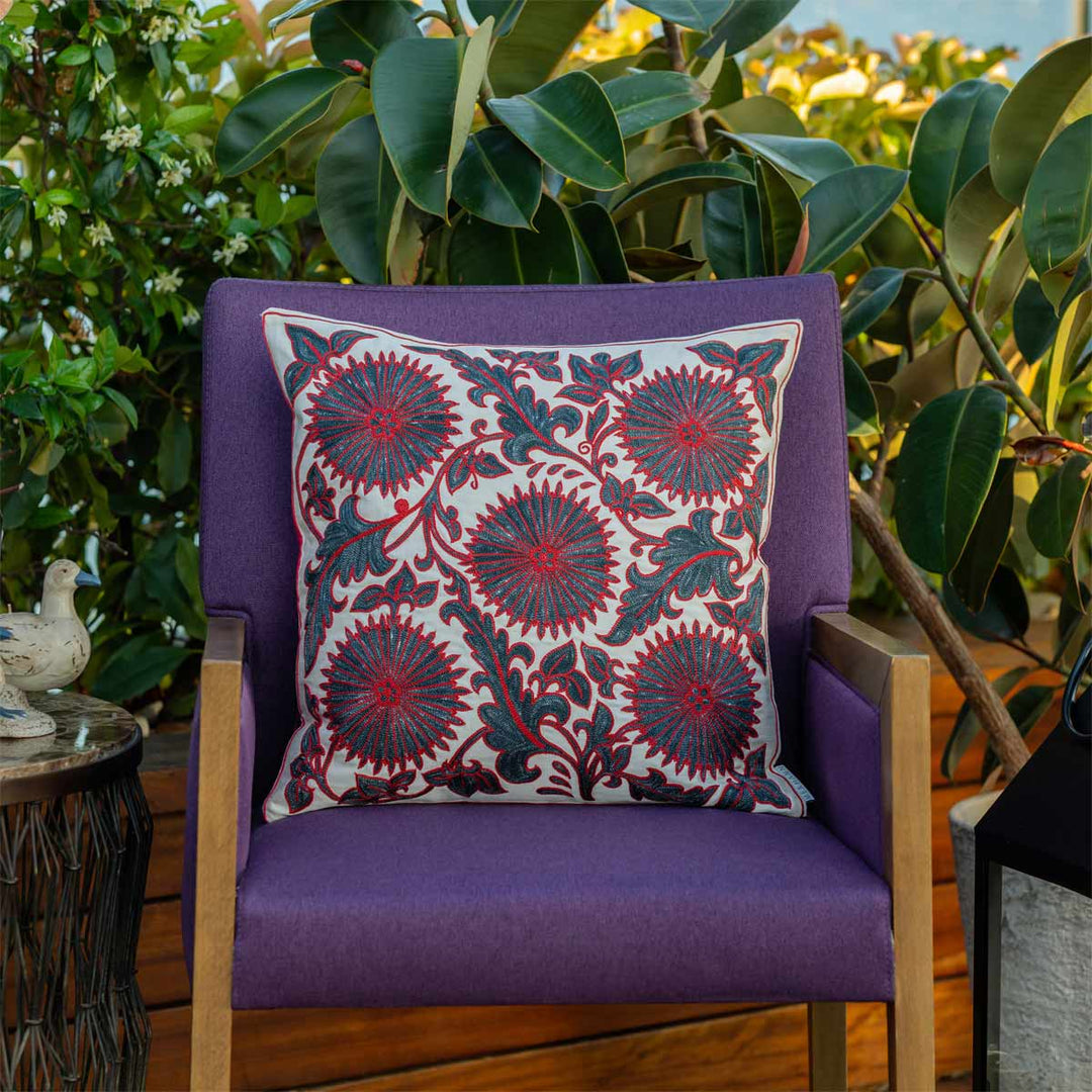 in use view of Mekhann's multicoloured Sunflower embroidered cushion,  here we can see the hand embroidered cushion placed on a chair outside.