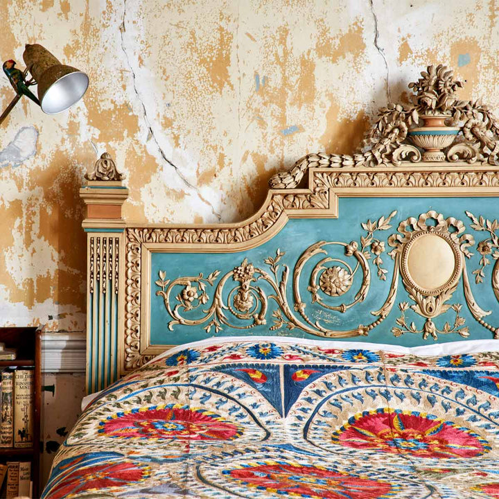 In use view of Mekhann's multicoloured medallion throw, where the full embroidered throw is the main component of a bead spread.