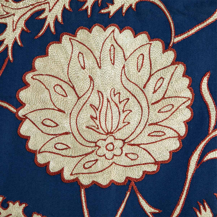 Close up view of Mekhann's navy botanical throw, we can see the attention to detail of the hand embroidered botanical details in the colour cream with a subtle red outline on a base of navy silk.