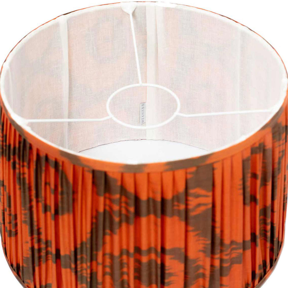 Interior view of Mekhann's hand-pleated orange ikat lampshade, highlighting the intricate silk weaving and natural dyes.