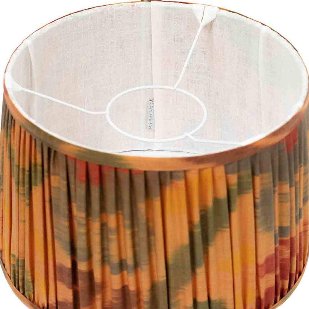Interior view of Mekhann's silk lampshade, showcasing the fine craftsmanship and warm orange hues from eco-friendly dyes.