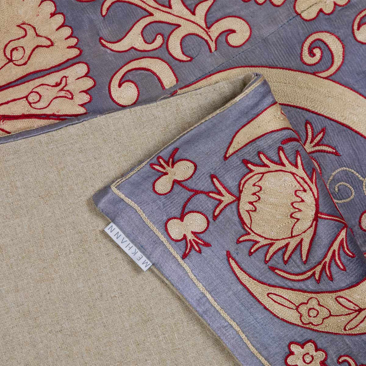 Folded view of Mekhann's pewter carnations throw, showing show the pewter silk front layer attaches to the back lining fabric of the throw.