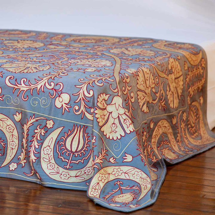 In use view of Mekhann's pewter carnations throw, shows draped across the foot of a bed spead.