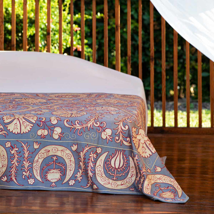 In use view of Mekhann's pewter carnations throw, showing the throw being used as the main element of a bed spread.