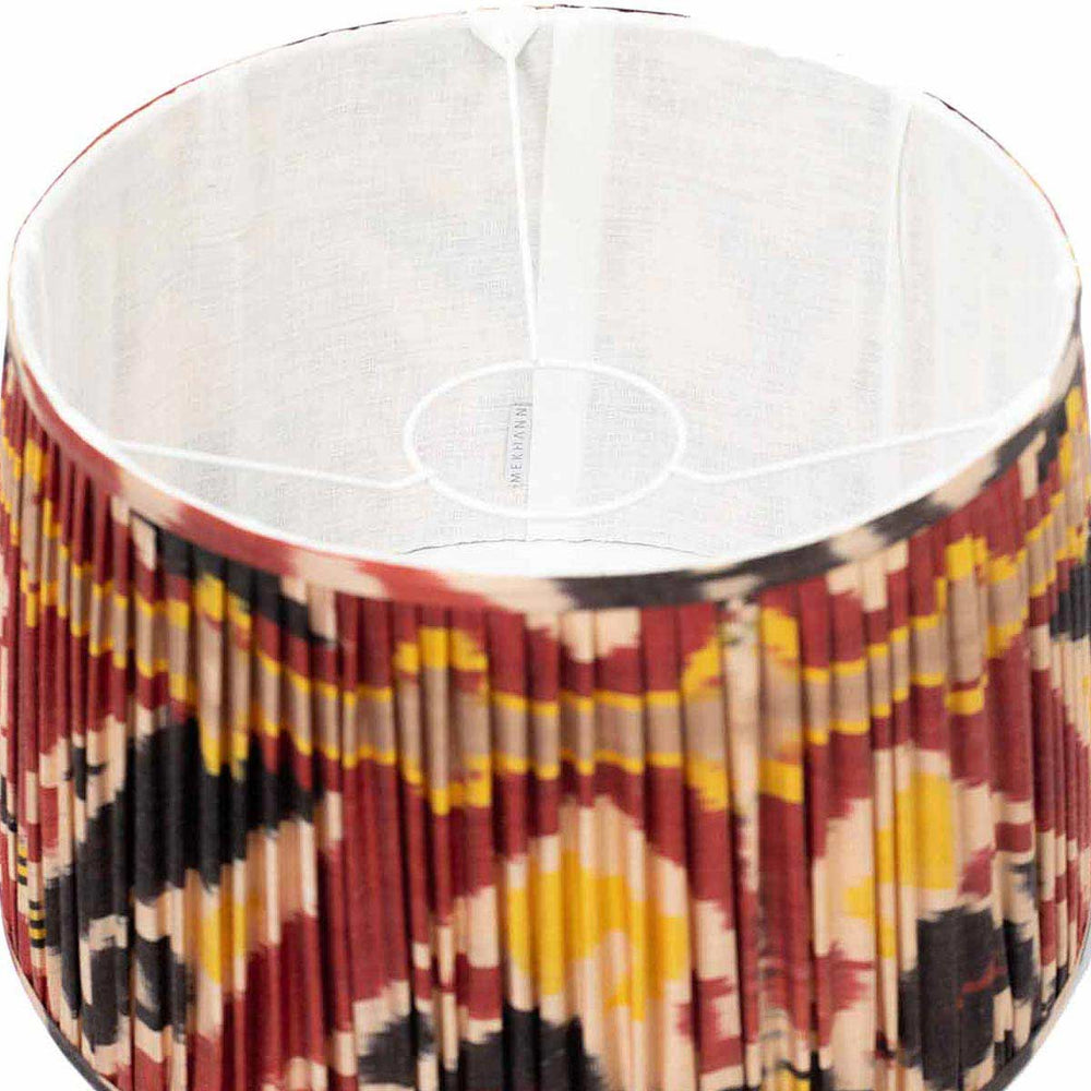 Interior view of Mekhann's hand-pleated red ikat silk lampshade, displaying the luxurious weave and vibrant colour palette.