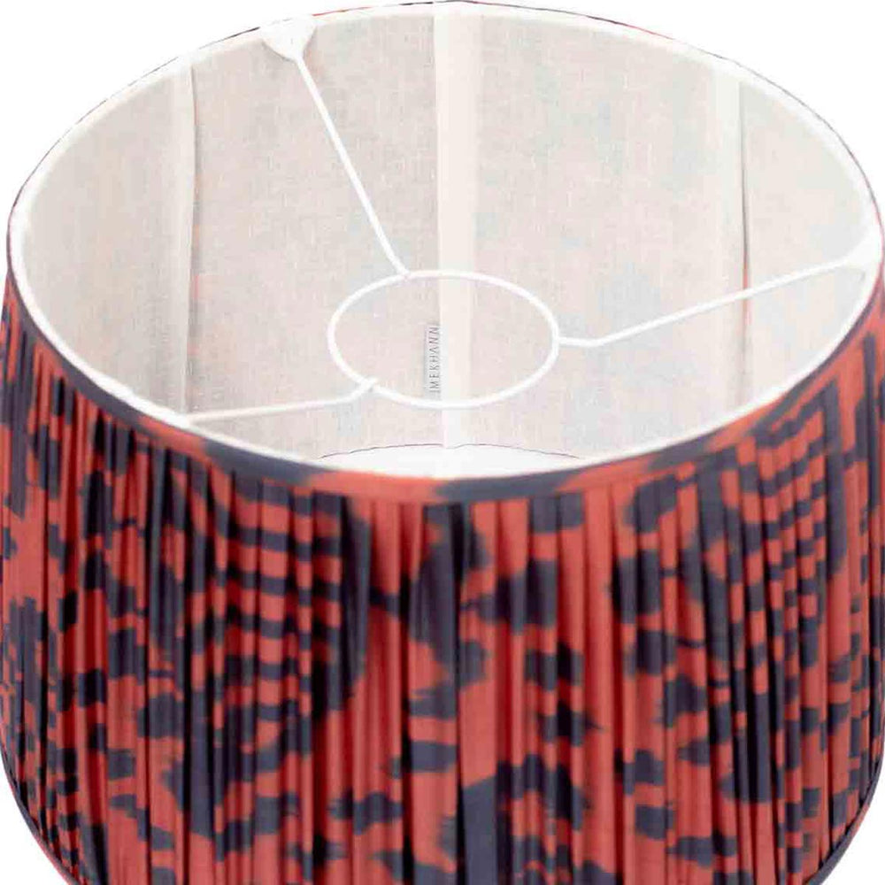 Interior glimpse of Mekhann's ikat lampshade, with a red and navy pattern that showcases intricate silk weaving and dye artistry.